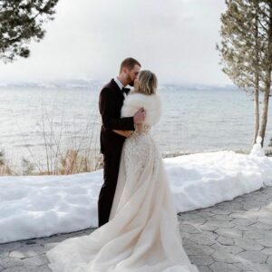 Bride and groom on a snowy mountain wearing fur